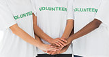 Team of volunteers putting hands together