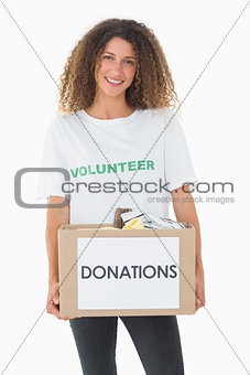 Smiling volunteer holding a box of donations