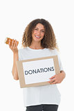 Happy volunteer holding a box of donations and jam jar