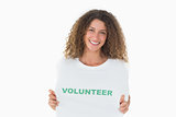 Smiling volunteer showing her tshirt to camera