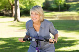 Woman riding bicycle in parkland