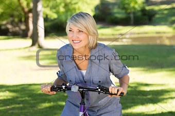 Woman riding bicycle in parkland
