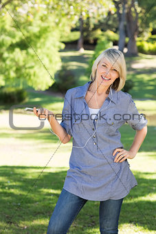 Happy woman listening music in park