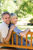 Smiling couple sitting on park bench