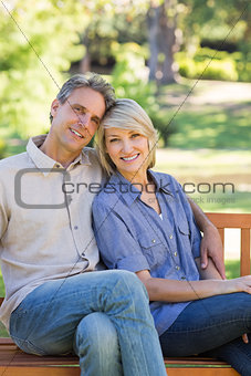 Smiling couple sitting on park