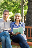 Couple with books on park bench