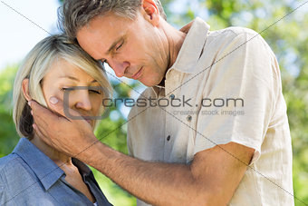 Man comforting woman in park