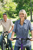 Beautiful couple riding bicycles in park