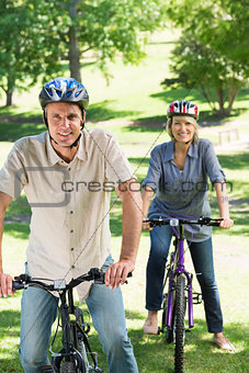 Couple riding cycles in park