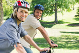 Happy couple riding bicycles in park
