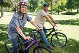 Happy couple cycling in a park