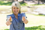 Woman gesturing thumbs up in park