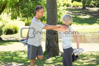 Couple stretching legs in park