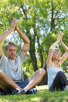Couple meditating in the park
