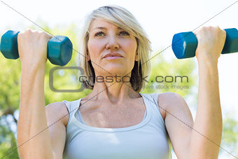 Woman lifting dumbbells in park