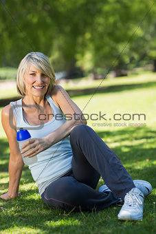 Sporty woman holding water bottle in park