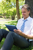 Businessman using tablet computer in park