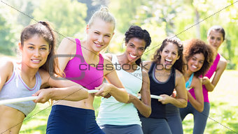 Women pulling a rope in park