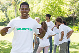 Volunteer pointing at tshirt in park