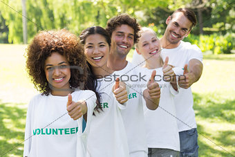 Confident volunteers gesturing thumbs up