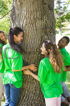 Environmentalists standing around tree trunk