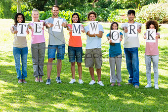 Friends holding placards reading teamwork
