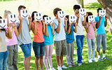 Friends holding smileys in front of faces