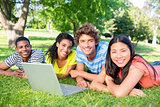 Students with laptop lying on campus