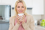 Beautiful young woman with coffee cup in kitchen