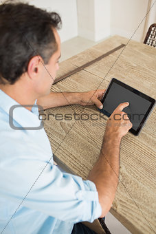 Concentrated man using digital table at home