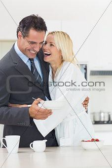 Cheerful woman embracing well dressed man in kitchen