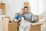 Smiling couple unpacking boxes in a new house