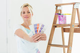 Woman holding out color swatches in new house