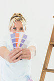 Woman holding blurred color swatches in new house