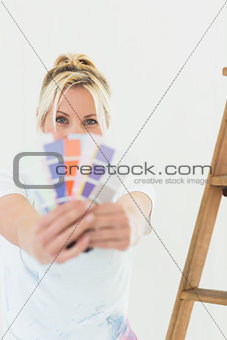 Woman holding blurred color swatches in new house