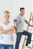 Couple with paint brush and ladder in a new house