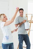 Couple with color swatches and ladder in a new house