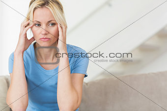 Worried young woman sitting in the living room