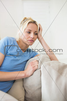 Worried young woman sitting in living room