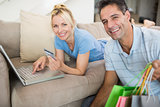 Portrait of smiling couple doing online shopping at home