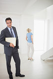 Well dressed real estate agent with blurred woman in background