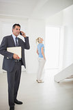 Real estate agent on call with blurred woman in background
