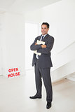 Smiling businessman with documents at an house for sale