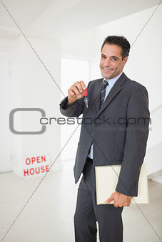 Businessman with documents holding up keys