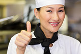 Portrait of smiling female cook gesturing thumbs up