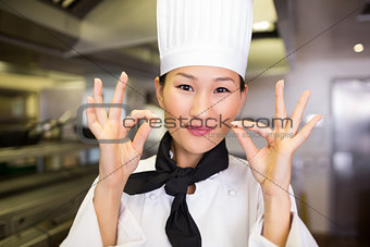 Closeup of a smiling female cook gesturing okay sign