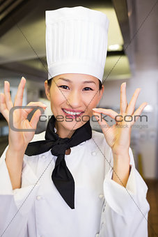 Closeup of smiling female cook gesturing okay sign