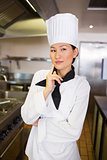 Portrait of thoughtful female cook in kitchen