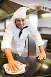 Portrait of a smiling male cook wiping kitchen counter
