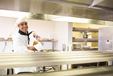 Smiling male cook with arms crossed in kitchen